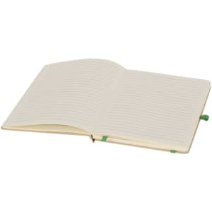 A notepad with lined pages, featuring a cream cover and a green ribbon bookmark. It has a logo on the front.