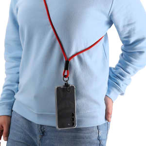 A charging cable in red with a lanyard, holding a smartphone near a person wearing a light blue sweatshirt.