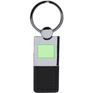A metal keyring with a shiny chrome finish and a black leather section, featuring a small green area.