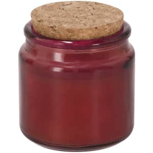 A red aromatic candle in a glass jar with a cork lid. The jar has a smooth finish and a rich, vibrant hue.