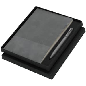 A black notebook with lined pages and a grey pen, packaged in a matching black box.