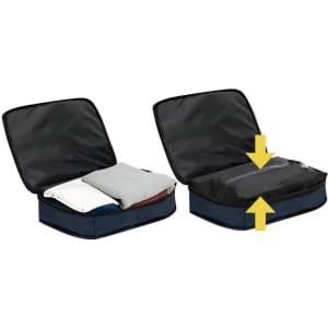 A navy blue vacuum backpack with an unzipped compartment showing folded clothes inside, demonstrating its expandable feature.