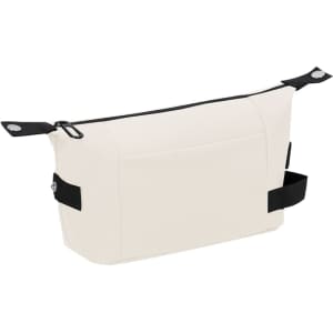 A cream toiletry bag with black accents and straps, featuring a single outer pocket and a logo.