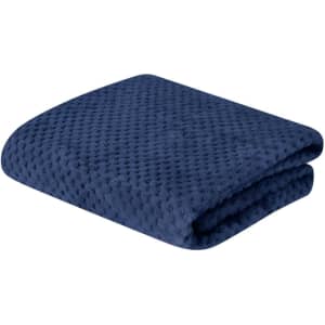 A folded navy blue blanket with a textured, soft surface. It features a subtle pattern and has a branding logo.