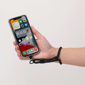 A black Whister Holder Bracelet attached to a smartphone, held by a hand against a plain background.