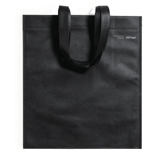 A black tote bag with two handles and a logo. It features a simple, sleek design.