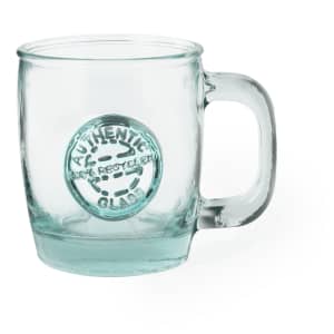 A clear glass mug with a handle, featuring a circular emblem and a textured surface.