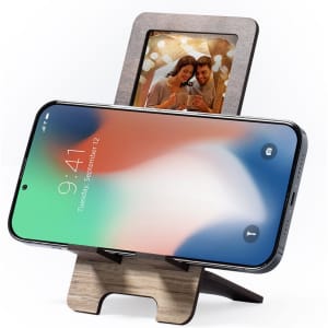 A wooden photo frame holder with a smartphone displayed, featuring a colourful background image of a couple.