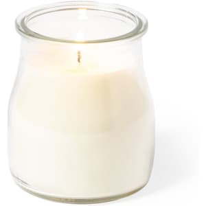 A white aromatic candle in a clear glass jar, featuring a lit wick. The jar has a classic shape and a simple design.