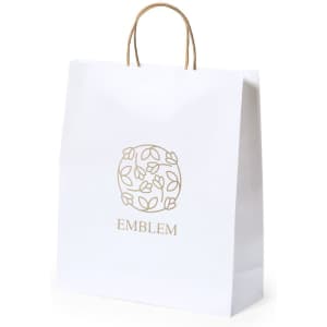 A white paper bag with a decorative logo and golden accents, featuring a sturdy handle for carrying.