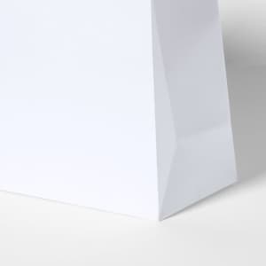 A white paper bag featuring a structured base and a slight glossy finish, complete with branding.