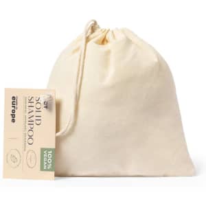 A natural cotton pouch containing solid shampoo, with a tag indicating it is 100% vegan. The pouch is beige.