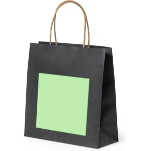 A black paper bag with a green square panel and brown handles. It features a logo on one side.