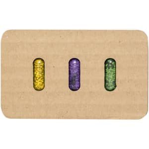 Three seed capsules in yellow, purple, and green, displayed on a rectangular cardboard backing with a logo.