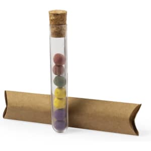 A clear test tube containing pastel-coloured bonbons, resting on a brown cardboard base.