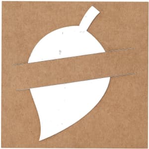 A white leaf-shaped piece of paper with two perforated lines, placed on a brown kraft background.