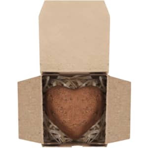 A heart-shaped chocolate bonbon nestled in a kraft box with straw fill. The packaging is simple and eco-friendly.