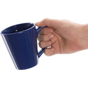 A blue coffee mug held in a hand, featuring a smooth finish and a comfortable handle.