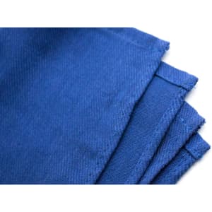 A blue fabric placemat with textured surface and folded edges, featuring a branding logo.
