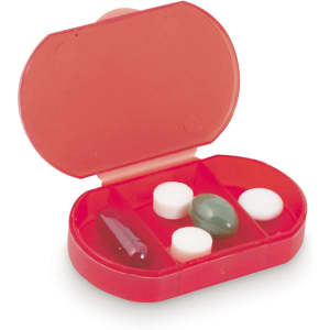 A red pillbox featuring four compartments holding various types of tablets, including a green capsule and white pills.