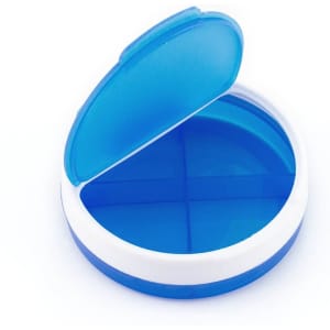 A blue and white pillbox with a hinged lid, featuring four compartments inside. It has a logo on the surface.