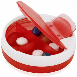 A red and white pillbox with sections inside, featuring various tablets and a hinged lid. It has a logo.