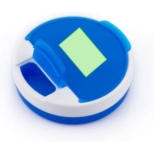 A round blue and white pillbox featuring a green compartment cover and a small opening for easy access.