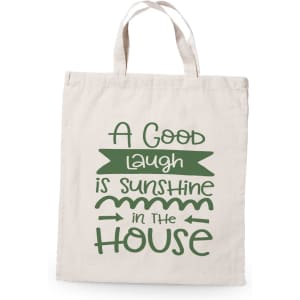 A beige tote bag featuring green text and a logo, with a playful saying about laughter.
