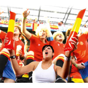 Two red and yellow inflatable cheering sticks held by a woman in a white tank top at a lively event.
