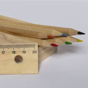 A set of grey-lead pencils in various colours—red, blue, green, orange, and black—next to a wooden ruler.