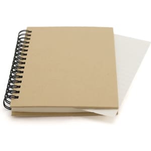 A brown spiral-bound notebook with blank pages and a lined insert partially visible. Features a black spiral binding.