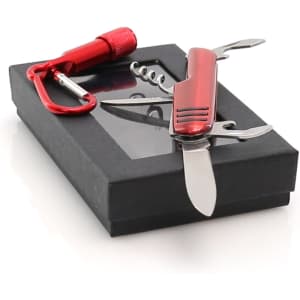A red multi-tool with knife, corkscrew, and screwdriver, accompanied by a red carabiner, on a black gift box.