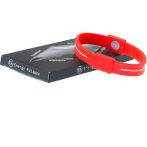 A red silicone wristband beside its packaging, featuring a logo on both the band and the box.