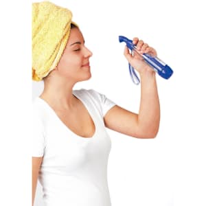 A blue vaporizer held by a woman with a yellow towel on her head, appearing relaxed and refreshed.
