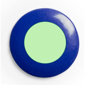 A round lapel pin featuring a blue outer ring and a green centre. It includes a logo.