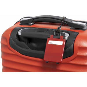 A red luggage tag is attached to a black suitcase handle, featuring a sleek design and a logo.
