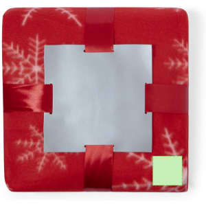 A red blanket featuring a snowflake pattern, secured with ribbons in each corner, and a central cut-out.