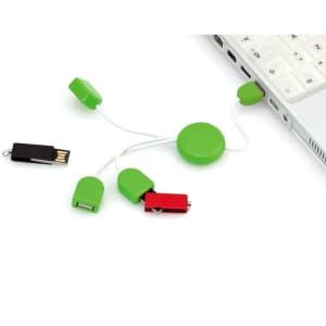 A green Pod USB Hub featuring multiple connectors, including a red one, connected to a laptop.