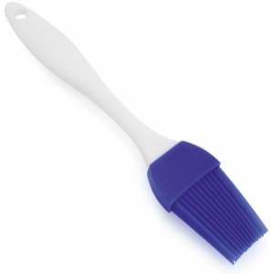 A silicone brush with a white handle and purple bristles, featuring a hole for hanging.