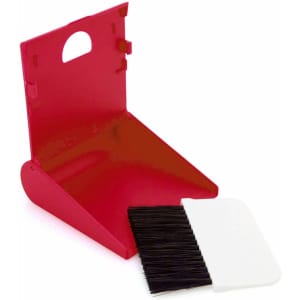 A red dustpan with a white brush. The dustpan features a handle and a compact design.