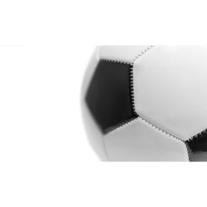 A close-up of a black and white soccer ball featuring hexagonal panels and visible stitching.