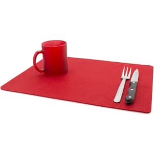 A red place mat with a red mug, silver fork, and knife arranged neatly on top.