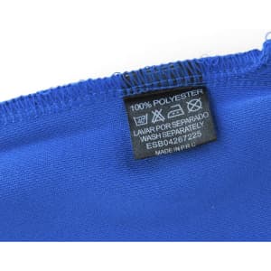A blue polo shirt featuring a care label that indicates it is made of 100% polyester.