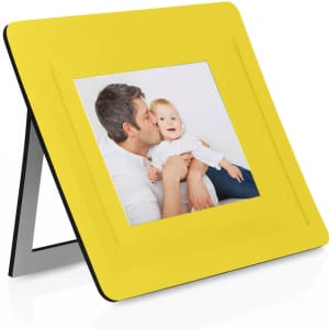 A yellow photo frame with a centrally placed picture, featuring a man and a child, stands on a black base.