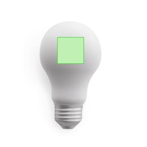 A white light bulb with a green square on its surface, featuring a standard screw base and a smooth finish.