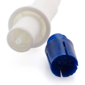 A blue component of a vaporizer next to a white connector attachment. The image has a blurred background.