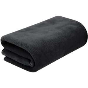 A folded dark grey fleece blanket featuring a soft texture. It includes a logo on the corner.