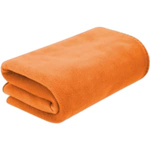 An orange fleece blanket neatly folded, featuring a soft texture and rounded edges. It has a branding logo.