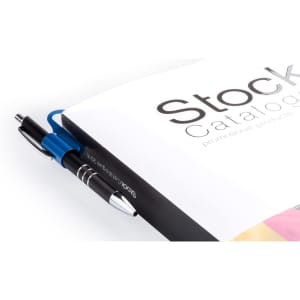 A catalogue with a black cover, featuring a blue and silver pen clipped to it. The pen has a branding logo.