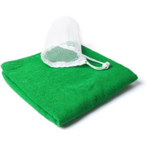 A green gym towel folded with a white mesh bag attached, featuring a drawstring closure.